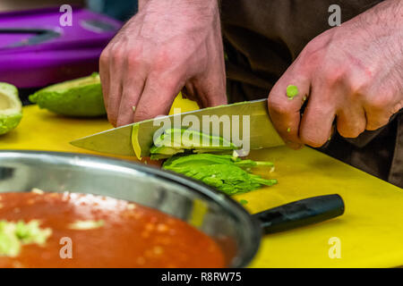 Male Chef Slicing Avocado for  Wedding Meal - Kitchen Set with Isolated Action, Only Chef`s Hands Stock Photo